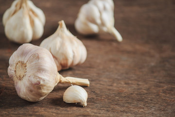 Garlic cloves and garlic on an old wooden table