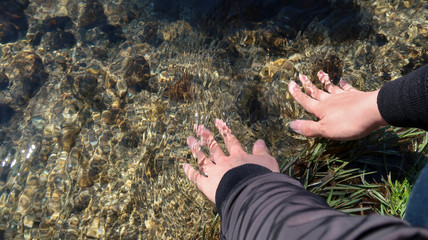川の水に触れる男性の手