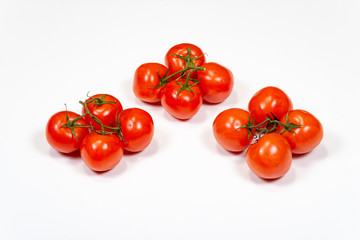Red tomatoes on a branch on a white background, top view