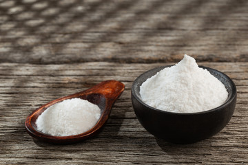 Baking soda on wooden background, space for text