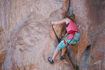 A girl climbs a rock.