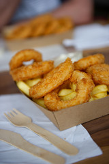 takeaway calamari and chips served in a cardboard plate