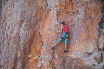 A girl climbs a rock.