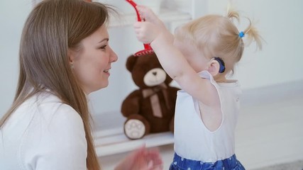 Concept of hearing impairment and their treatment. Cute little girl with a hearing aid