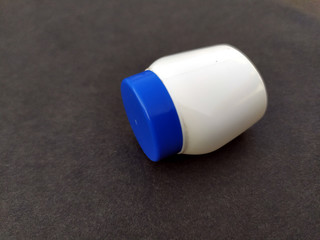 a white and blue plastic bottle isolated on seamless background