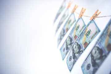 Washing money concept. 100 Dollar bills hanging on a washing line. Symbol of money laundering. Copy space soft focus.