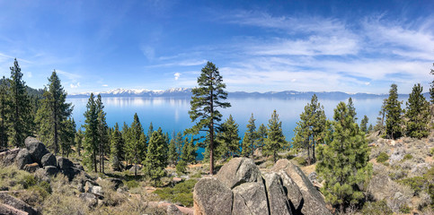 Beautiful Lake Tahoe with pine trees and rocks along the bank