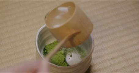 Part of a Japanese tea ceremony. Close-up of pouring and whisking of Japanese matcha (green tea).