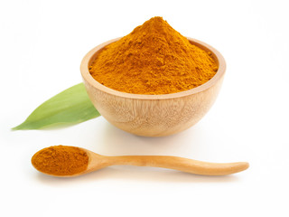 turmeric powder or curcuma longa in a wood bowl with green leaf and spoon use as ingredients cosmetics products and is a anti inflammatory, antioxidant, including is a herb use for health care concept