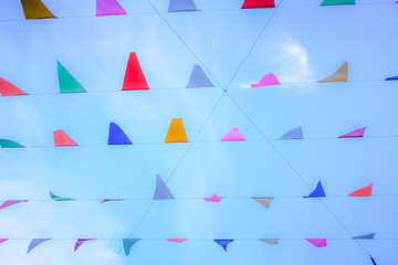 Triangle colorful flags decoration at party or temple fair with blue sky background