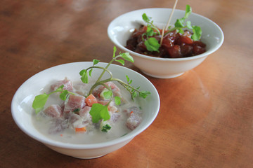 Raw fish in coconut cream (white colour) and poke, the marinated tuna sashimi with soy sauce,...