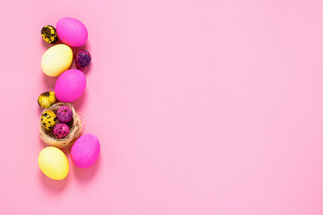 Happy easter concept. Colored eggs on a pink background. Copy space flat layout. Banner with place for advertising.