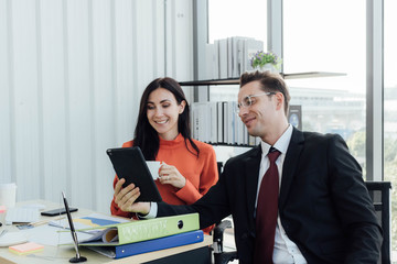 Two business people discussing about work in an office.