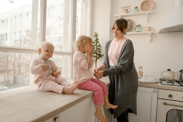 A young mother spends time with her little daughters at home.