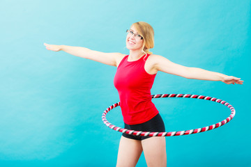 Fit woman with hula hoop doing exercise