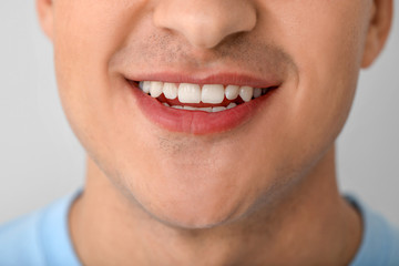Fototapeta premium Handsome smiling man on light background, closeup