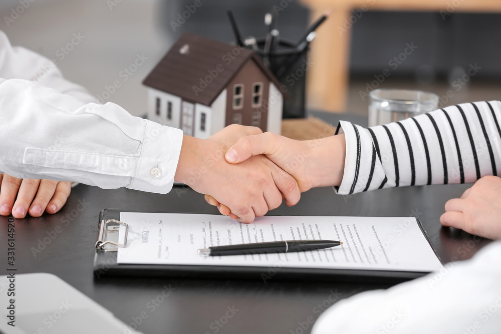 Wall mural Little real estate agent with client shaking hands in office