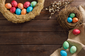 Still life many colorful easter eggs on a wooden background. Rustic. Decoration from natural fabrics and herbs. Easter celebration concept. Flat lay