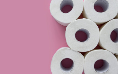 .Rolls of white toilet paper on a pink background copy space. Shortage of toilet paper flat lay.