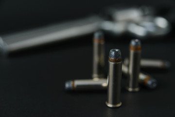 357 Caliber hollow point bullets near revolver pistol gun on black background