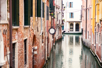 Picturesque Old Venice Canal with Red Buildings and Boat.