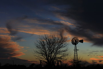 Kansas colorful Sunset with a Windmill silhouette out in the country.