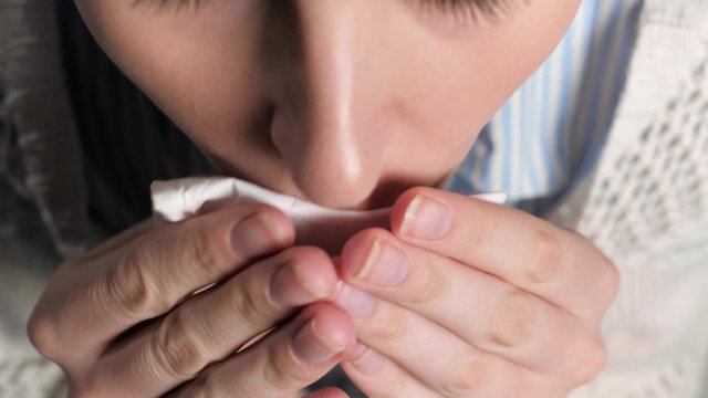 Girl coughs and covers her mouth with napkin. Colds, flu, laryngitis, tuberculosis, asthma, bronchitis, allergies, pneumonia, APF inhibitors, nasopharyngeal leakage concepts. Top view. Close-up