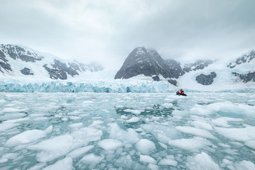 iceberg in antarctica south pole sea with zodiac boat 