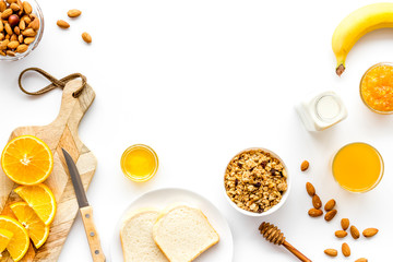 Morning granola near toast and oranges on white background top-down frame copy space
