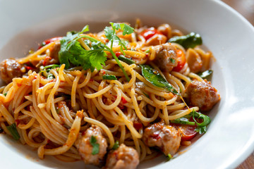 Selective focus, Spaghetti pasta with meatballs and tomato sauce. spaghetti and meatballs with oregano garnish on white plate. Spicy Spaghetti pasta with meatballs and spicy sauce.