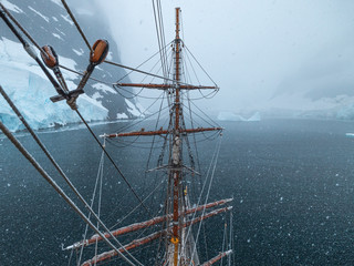 sailing ship in lemaire channel antarctica with snow 