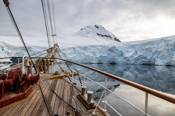 sailing ship in the bay in the front of a glacier in antarctica 