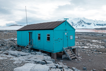 Obraz na płótnie Canvas mountain hut in the snow on the shore of antarctica close to port lockroy 