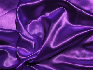 Smooth purple fabric or satin texture background with copy space for design