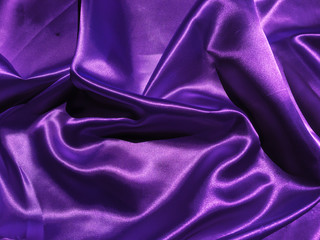 Smooth purple fabric or satin texture background with copy space for design