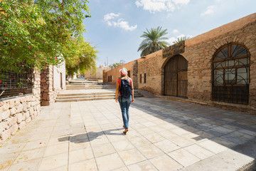 Fototapeta na wymiar Tourist with backpack walking on street in Aqaba, Jordan.
