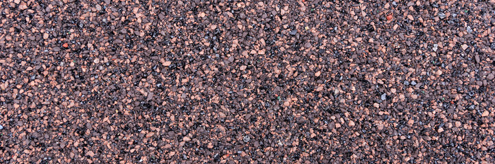 Closeup red and black bitumen shingles. Rough background made of roofing material