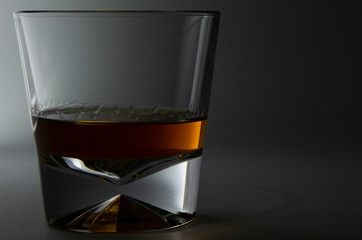 glass of whiskey and ice on black background