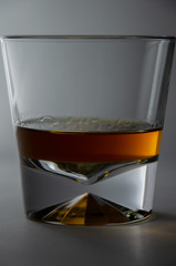 glass of whiskey and ice on black background