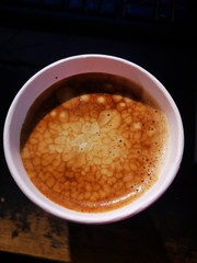 Coffee beans with cream in a paper cup