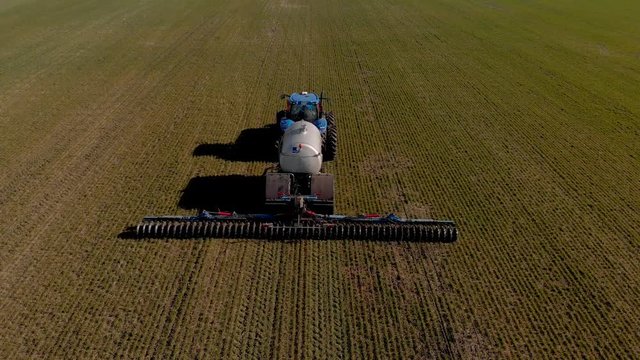 The introduction liquid mineral fertilizers into soil with tractor winter wheat
