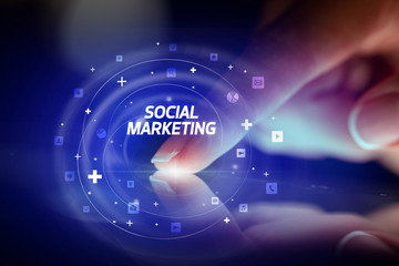 Finger touching tablet with social media icons and SOCIAL MARKETING