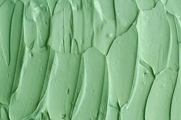 Fotobehang Pistache Groene cosmetische klei (komkommer gezichtsmasker, avocado gezichtscrème, groene thee matcha body wrap) textuur close-up, selectieve focus. Abstracte achtergrond met penseelstreken.