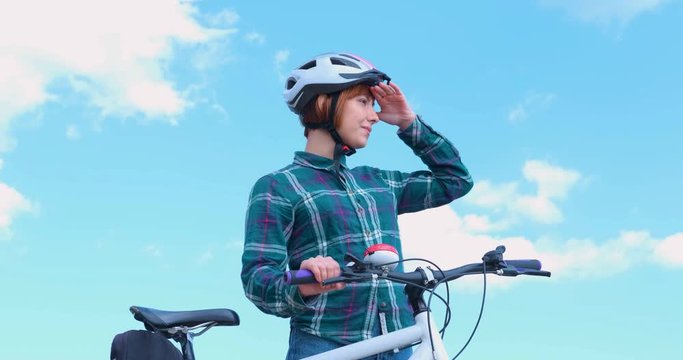 Young woman bicycle rider in sunny summer day 