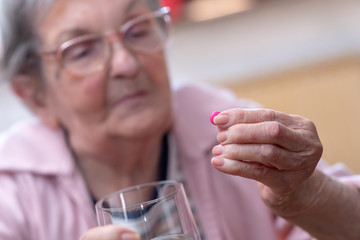 Elderly woman taking her medicine