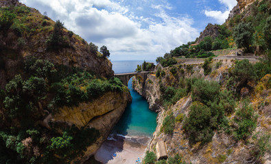Aerial view inside bay of Fiordo di furore beach. Incredible beauty panorama of a mountains paradise. The rocky seashore of southern Italy. Sunny day. Stone bridge and clear water. Amalfi. No people