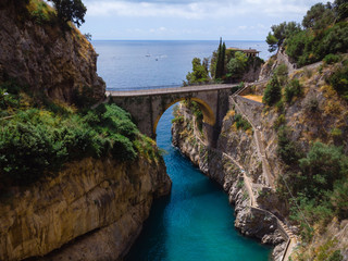 Aerial view of stone bridge and blue sea water. Incredible beauty panorama of a mountains bay. The rocky seashore of southern Italy. Sunny day. Fiordo di furore beach Amalfi coast.