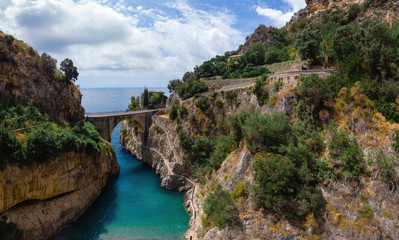Fototapeta na wymiar Aerial view inside bay of Fiordo di furore beach. Incredible beauty panorama of a mountains paradise. The rocky seashore of southern Italy. Right copy space. Stone bridge and blue water. Amalfi