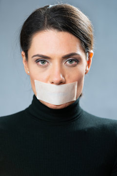 portrait of a woman with closed mouth a white tape. censorship concept. restraint or understatement.