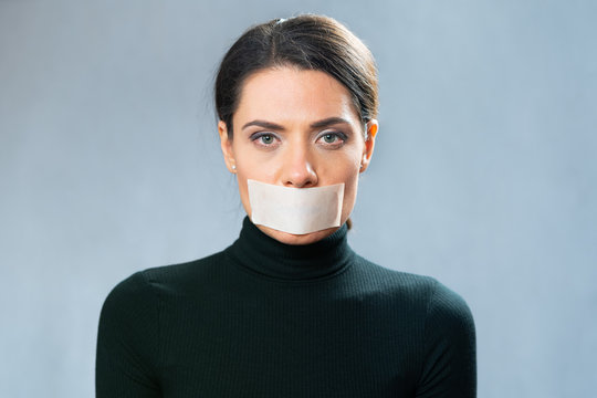 young lady with closed white ribbon mouth, closeup portrait. involuntary silence. censorship